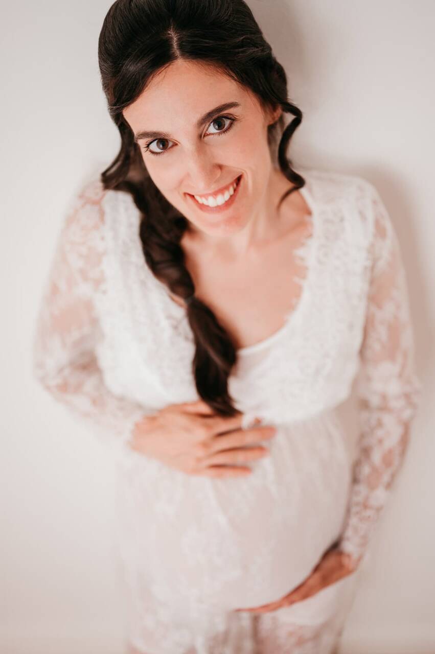 Futura mamma in gravidanza che ha fatto la sessione fotografica di gravidanza al momento giusto fotografata in stile minimal con abito bianco di pizzo